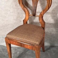 Six Biedermeier walnut chairs- one chair in three-quarter view- styylish