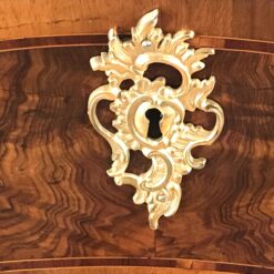 Original 18th century ormolu escutcheons on a German Baroque chest of drawers, highlighting historic craftsmanship and refined design.