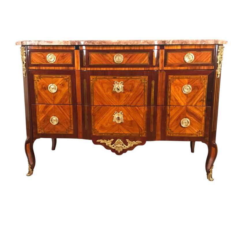 French Louis XV-Transition chest of drawers, circa 1770–1780, with satinwood, rosewood, and kingwood veneer, rose-beige marble top, original bronze mounts, and three drawers.